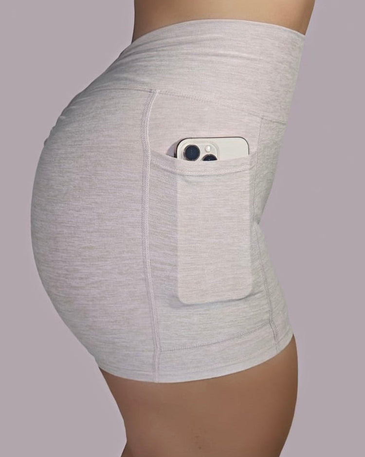 Side view of CHERRY-ACTIVE™ High-Waist Scrunch Pocket Shorts in light beige, showing phone pocket detail and sculpted fit.